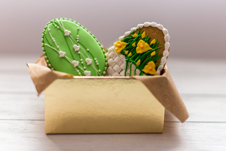 Easter cookies in a box on grey wooden background, two big cookies with lilly
