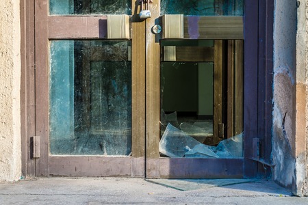 Broken old glass door with steel lockの写真素材