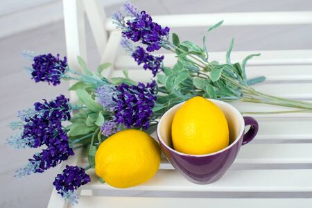 Still life with fresh lemons and lavender on a white chair top viewの写真素材