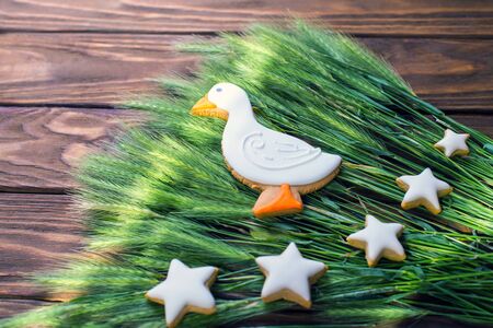 Gingerbread cookies shaped duck and stars with  ear of wheat on a wooden brown background. Shallow depth of field.の写真素材