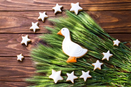 Gingerbread cookies shaped duck and stars with  ear of wheat on a wooden brown background. Shallow depth of field.の写真素材