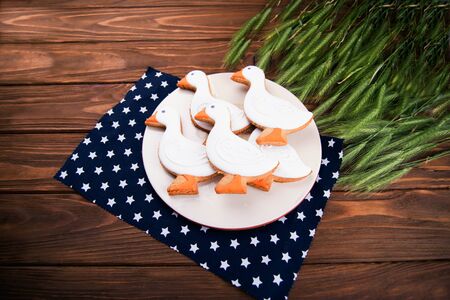 Tasty gingerbread suck shaped cookies on a plate with ear of wheat on a bown wooden backgroundの写真素材