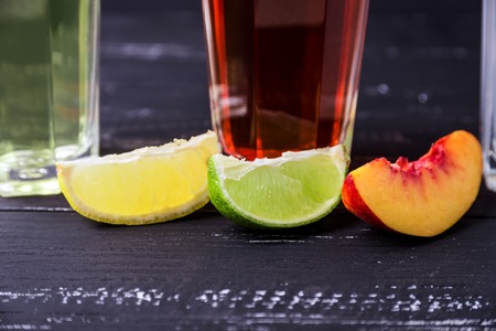 Top view of three slices of different fruit and glasess with coctails on a background.の写真素材