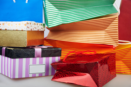 Colourful paper shopping bags and boxes against blue background