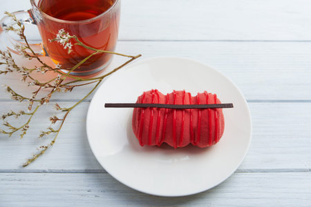 Top view at mini cake with strawberry cream, dark chocolate and creamy mousse and cup of tea on a...