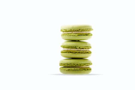 Three gentle green pistachio macarons isolated on whiteの写真素材