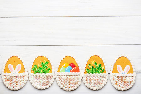 Colorful easter cookies with different pattern in egg shape on white wooden background at the...