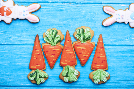 Colorful easter rabbit and carrot cookies on blue wooden background . Top view.の写真素材