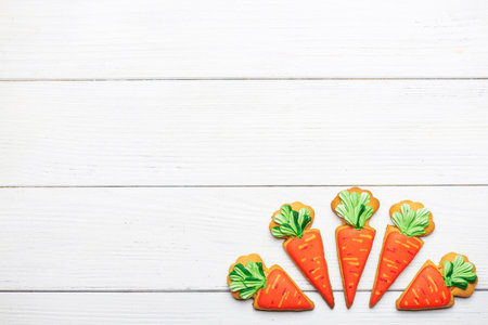 Delicious cookie carrots on the right corner on a white wooden background with copy space. Top view.の写真素材