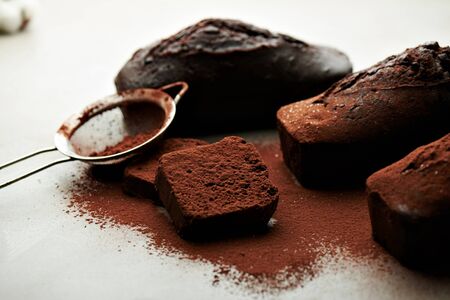 Close view at slice of tasty chocolate cake and cocoa on top on a grey background.の写真素材