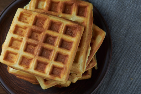 Top view at plate of belgium waffles on a dark wooden rustic background