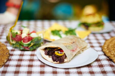 Pita sandwich with grilled meat with fresh salad food outdoor. Shallow depth of field.の写真素材