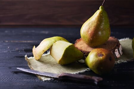 Fresh green pears and knife on a rustic background on a napkin. Vertical shotの写真素材