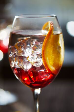 Close view at refreshing red cocktail with orange bokeh backgroundの写真素材