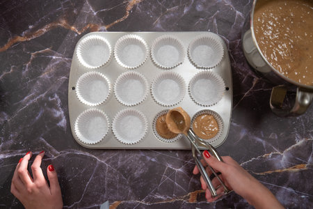 woman with baking tray for making cupcakes on a dark marble backgroundの写真素材