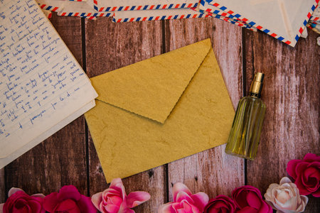 Valentine's day background surrounded by old and romantic letters with roses on wood, perfume bottle...