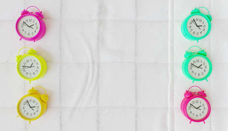 pastel colored alarm clocks on the sides of a bed. 3d renderingの写真素材