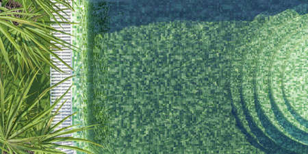 aerial view of green tiled swimming pool with round stairs and palm leaves on one side with space...