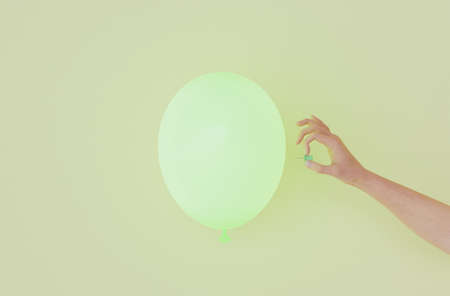 green balloon with a hand going to poke it with a thumbtack. 3d renderの写真素材