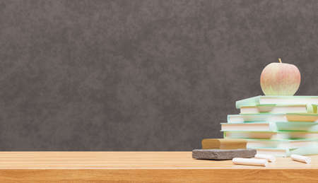 close-up of school table with books and chalk and blackboard in the background. back to school. copy...