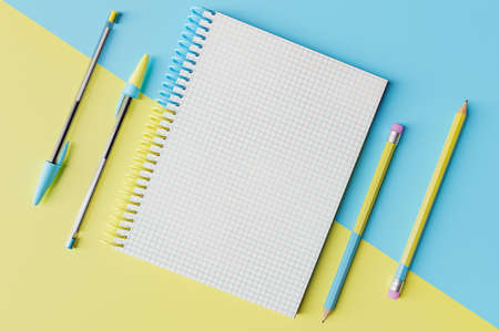 checkered notebook with pens and pencils with diagonally divided color. education concept. 3d...