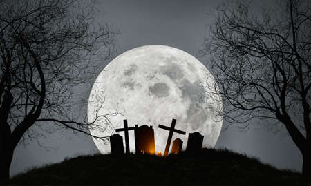 Halloween background of a cemetery on top of a hill with dry trees on the sides and huge moon behind. Halloween concept, parties and celebration. 3d renderingの写真素材
