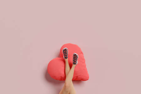 girl's legs resting on a heart shaped cushion. minimal concept of valentine, love and single. 3d renderingの写真素材