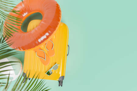 suitcase with summer travel accessories and palm tree leaves on top. space for text. concept of summer, vacations, travel, destinations, beach and swimming pool. 3d renderingの写真素材