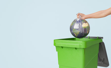 Conceptual 3D rendering of crop unrecognizable female throwing Earth globe covered with plastic bag into green waste container against pale blue backgroundの写真素材