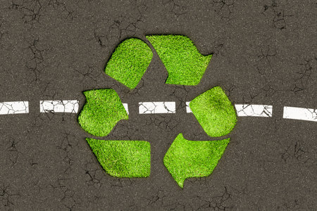 Top view of 3d rendering illustration representing green grassy recycle logo placed on cracked asphalt roadの写真素材