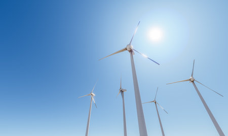 Wide angle shot of several wind turbines with the sun behind and a clear sky with space for text. 3d...
