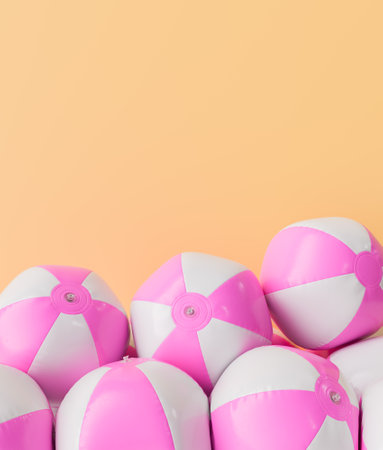 3D rendering of multiple pink and white beach balls stacked with an ample copyspace on a peach-colored background. Summer fun concept.の写真素材