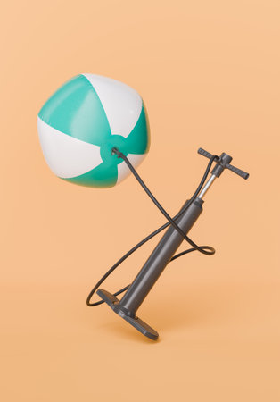 White and turquoise beach ball attached to a black air pump against a peach-colored background. Concept of summer fun preparation. 3d renderingの写真素材