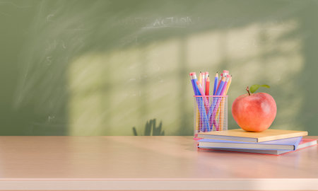 An apple and a cup filled with colorful pencils sit on top of books on a desk in front of a chalkboard in a classroom with sunlight streaming in. Education and healthy snack concept. 3d renderingの写真素材