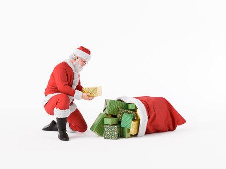 Santa Claus kneeling and picking up a Christmas gift from a pile of Christmas presents overflowing from a sack. 3d renderingの写真素材