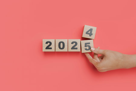 Hand changing wooden cubes from 2024 to 2025 on red background. Transition to the new year. 3d renderingの写真素材