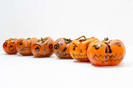 Jack - o ' - lantern, Halloween monsters - muzzles drawn on persimmon fruit. Persimmon is very similar to a pumpkin, the same orange and cheerful.の写真素材