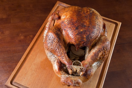 Oven roasted whole turkey resting on wood cutting boardの写真素材