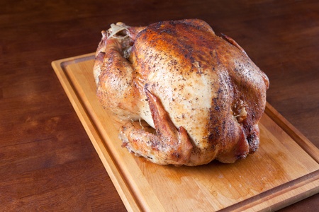Oven roasted whole turkey resting on wood cutting boardの写真素材