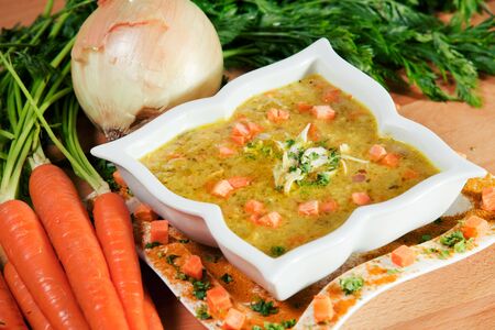 Hearty homestyle carrot soup, well seasoned and garnished with fresh carrots and onionsの写真素材