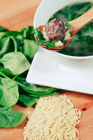 Bowl of Italian Wedding Soup garnished with orzo and spinachの写真素材