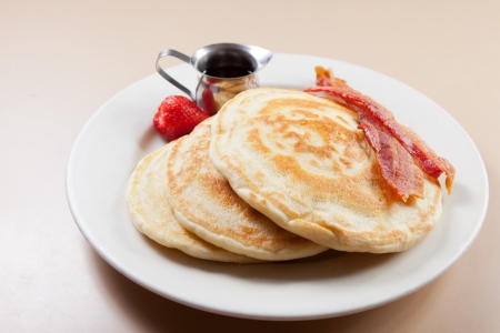 pancakes with bacon, strawberries and syrupの写真素材