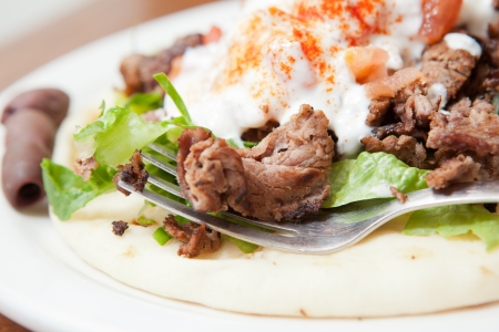 Close up look at lamb gyro and fork on a plateの写真素材