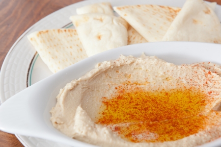 Bowl of hummus with olive oil and pita breadの写真素材