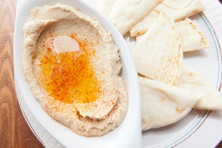 Bowl of hummus with olive oil and pita breadの写真素材
