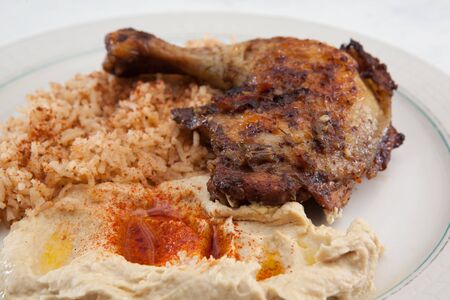 Plate of roasted chicken, saffron rice and hummusの写真素材