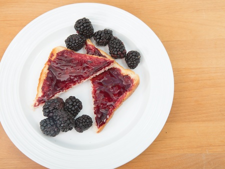 Plate of toast with jam and fresh blackberriesの写真素材