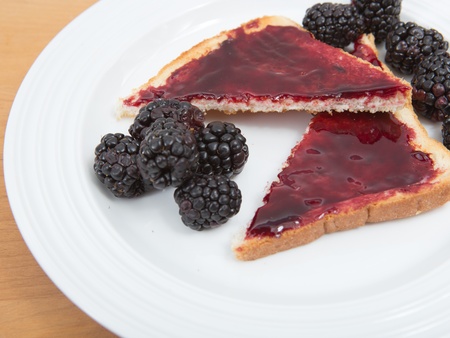 Plate of toast with jam and fresh blackberriesの写真素材