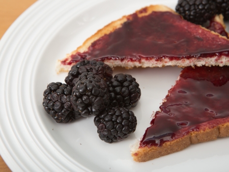 Plate of toast with jam and fresh blackberriesの写真素材