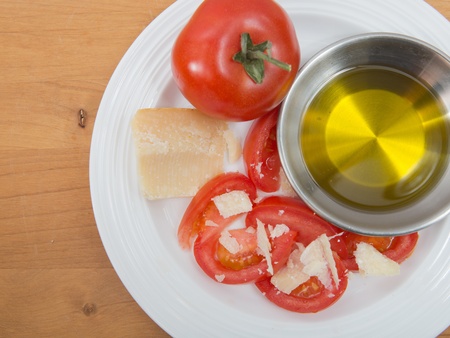Plate of vine ripened red tomato with parmesan and olive oilの写真素材
